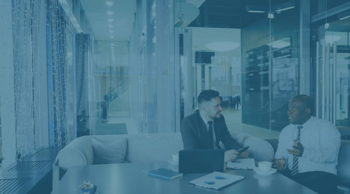 Two business professionals discussing heads of terms during a company sale meeting