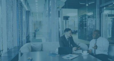 Two business professionals discussing heads of terms during a company sale meeting