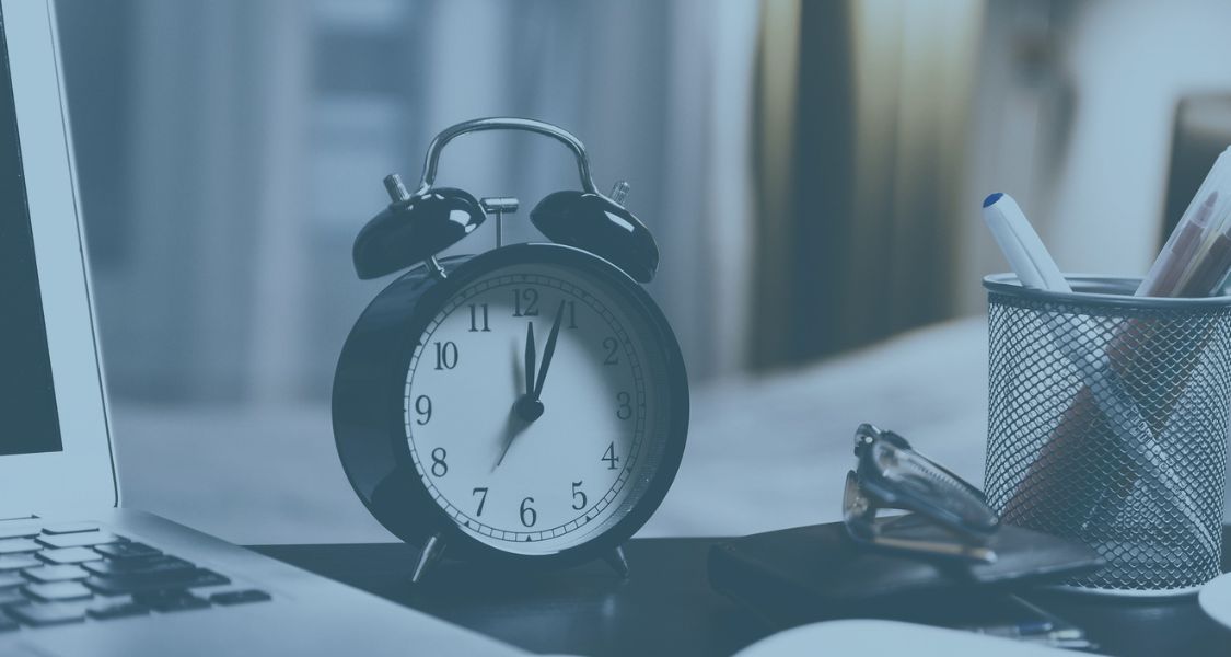 Alarm clock close up next to documents to show deadline for s21 is soon