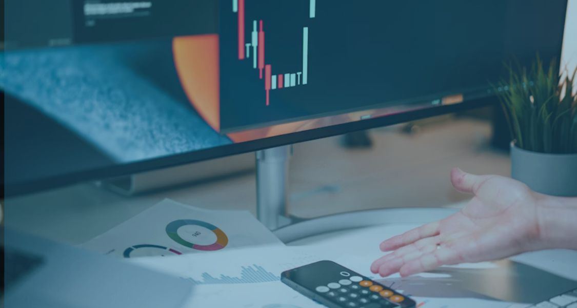 Business owner reviewing volatile financial charts and calculator on a desk, illustrating the risk of earn-out manipulation in M&A deals