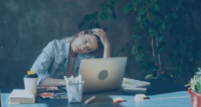 Stressed business owner at laptop reviewing finances, illustrating UK company directors under financial pressure considering refinancing or a debt‑for‑equity swap.