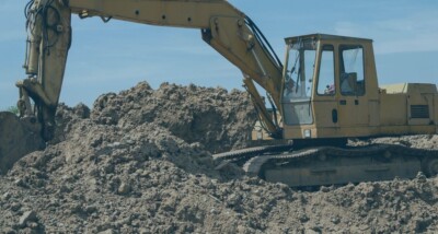 Excavator on a construction site symbolising construction payment and smash and grab adjudication issues.