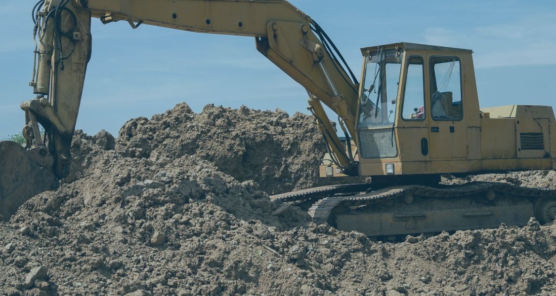 Excavator on a construction site symbolising construction payment and smash and grab adjudication issues.