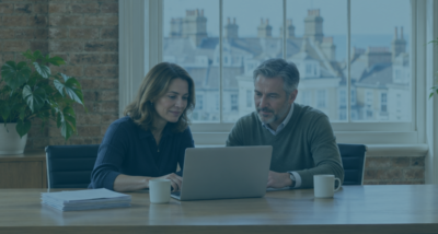 HR manager and business owner reviewing a data subject access request (DSAR) on a laptop in a bright Brighton office, with printed documents beside them.