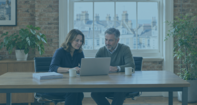 HR manager and business owner reviewing a data subject access request (DSAR) on a laptop in a bright Brighton office, with printed documents beside them.