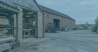 Joinery workshop and adjoining red-brick warehouse near Norwich, illustrating a business demerger.