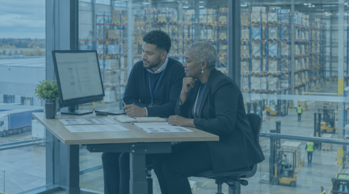 HR director and recruitment manager reviewing candidates at a logistics office overlooking a warehouse, illustrating AI recruitment.